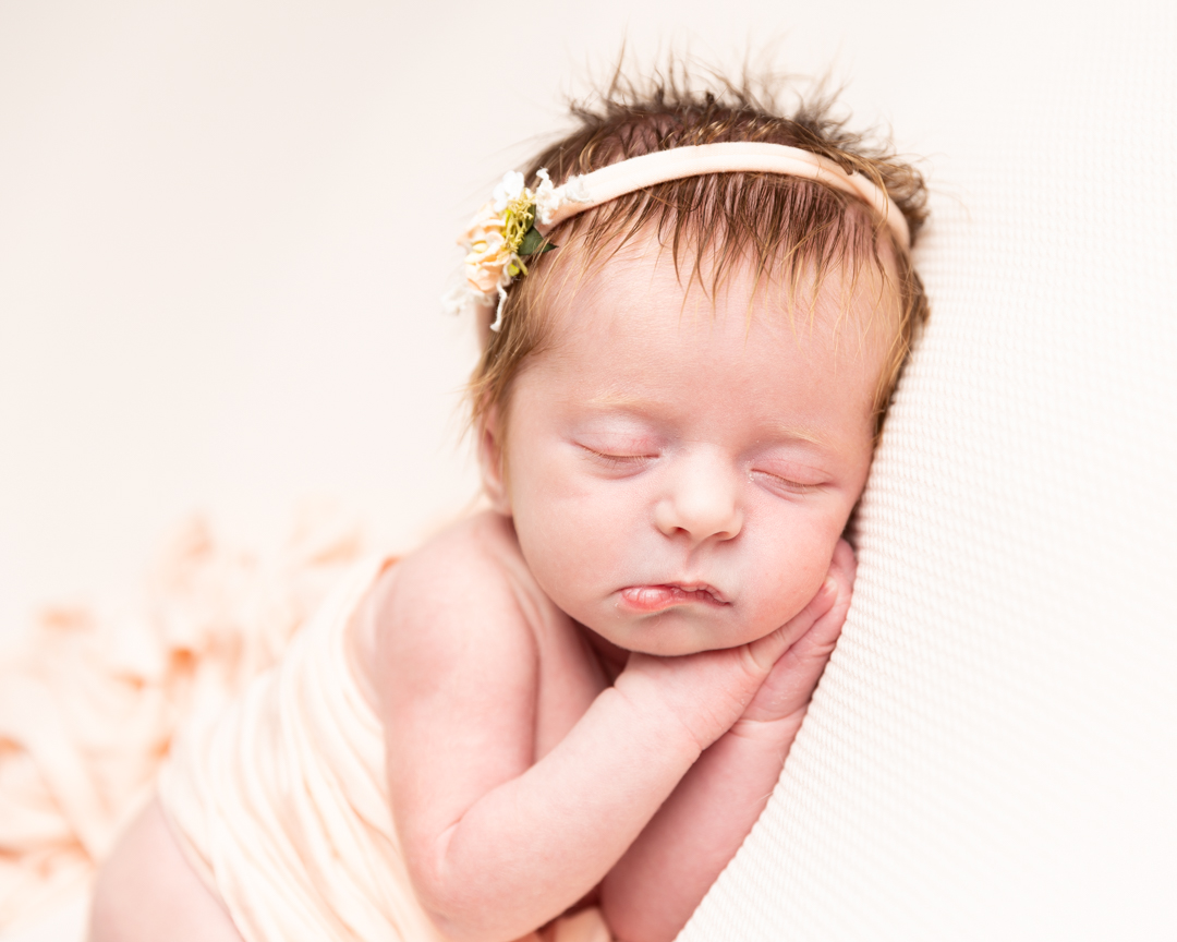 new born baby girl asleep with hairband and wrap