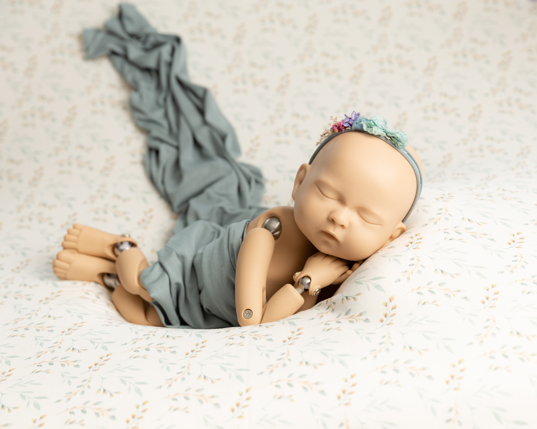 Newborn sized doll posed for newborn baby photographs