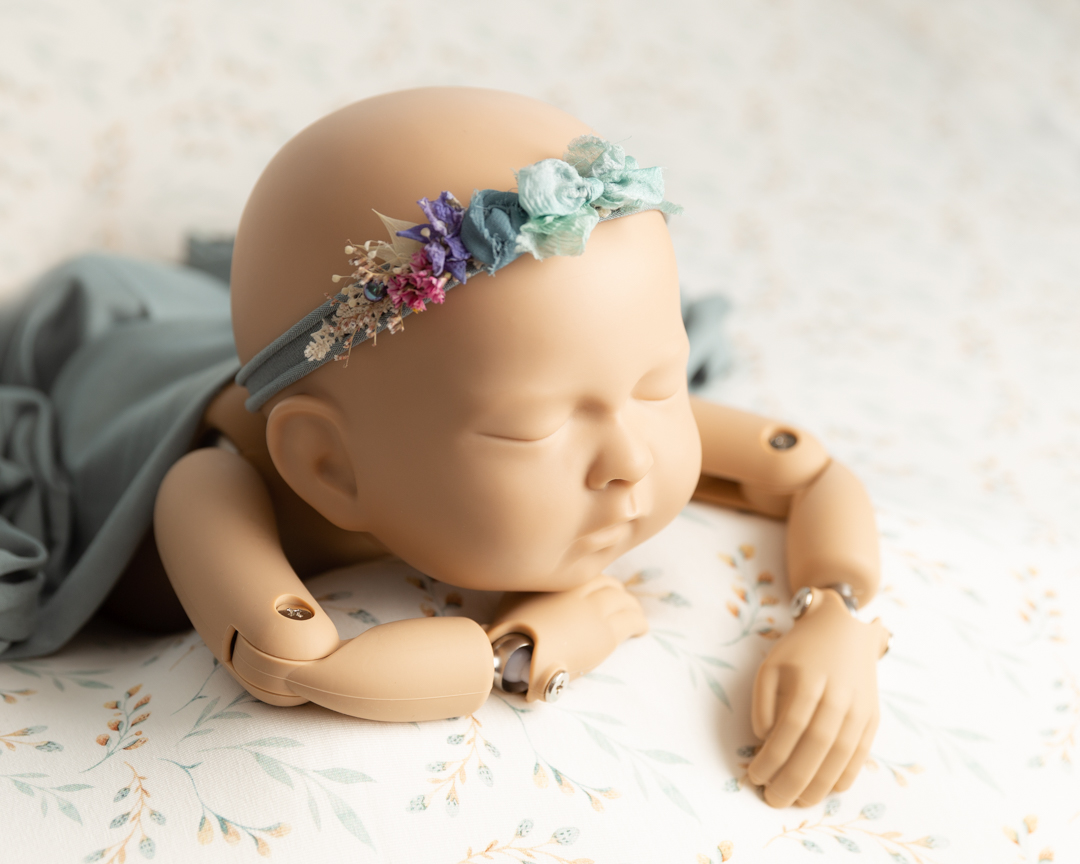 flower headband highlighting on newborn doll during photography shoot