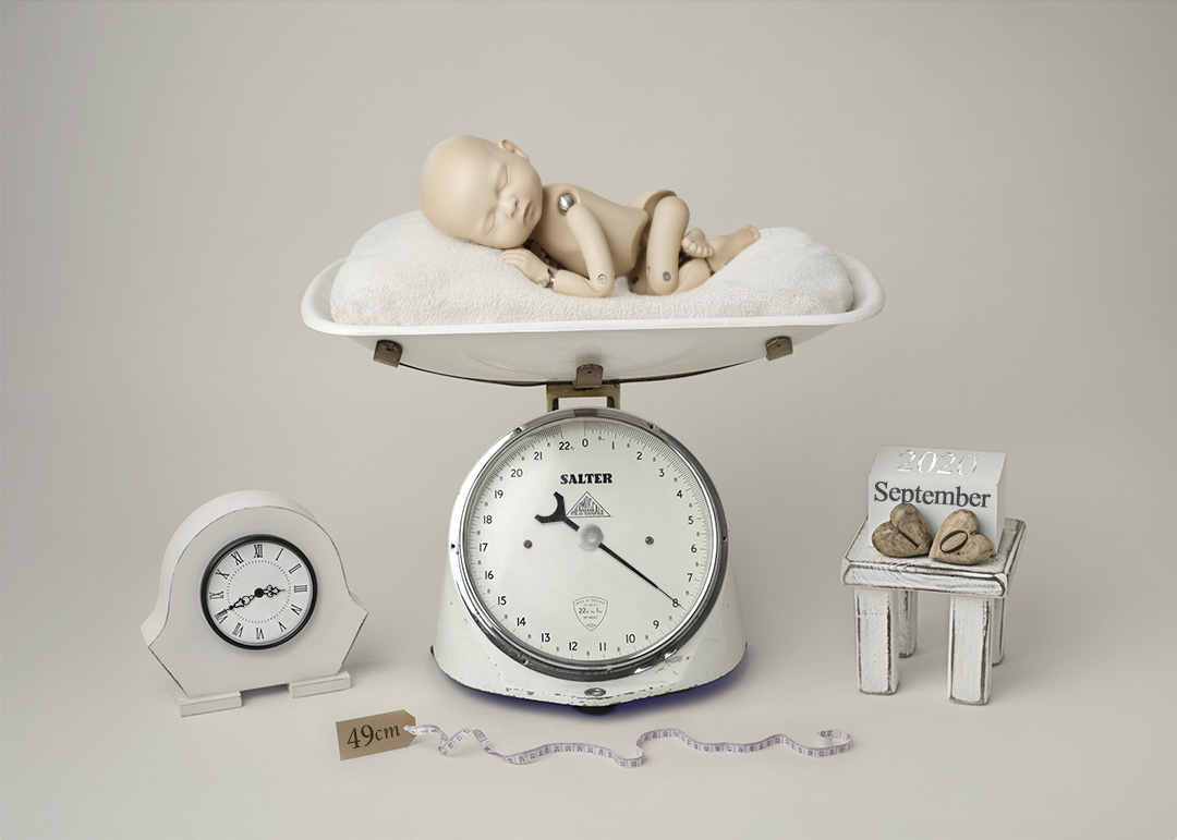 baby doll lying on a set of digital scales as part of a birth announcement