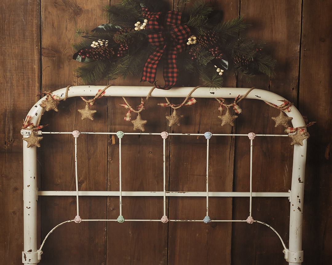 Cream metal bedhead on a wooden wall dressed in a Christmas Theme 