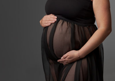 Image of a lady's pregnancy bump covered by sheer black fabric